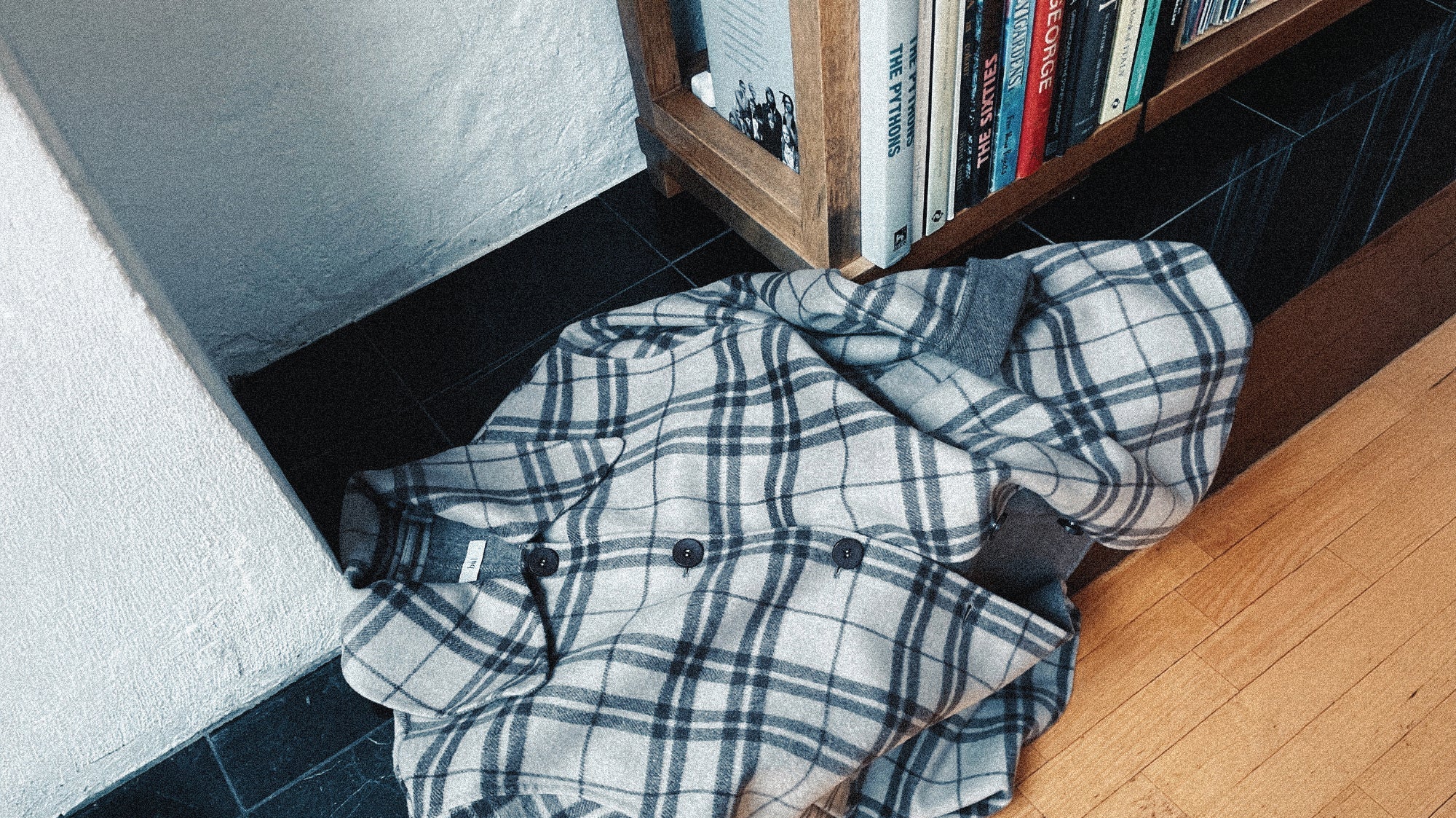 Checked coat next to bookcase