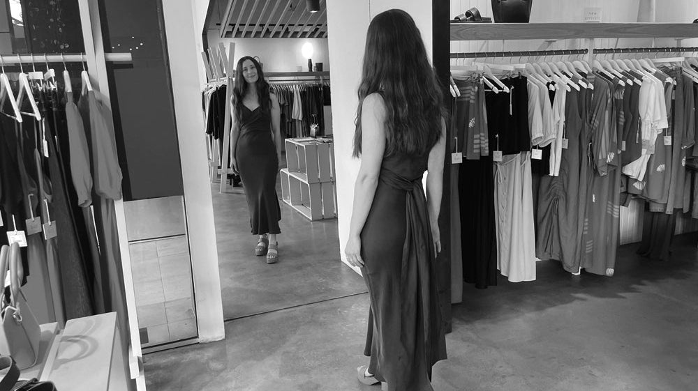 Person standing in front of a mirror trying on a dress
