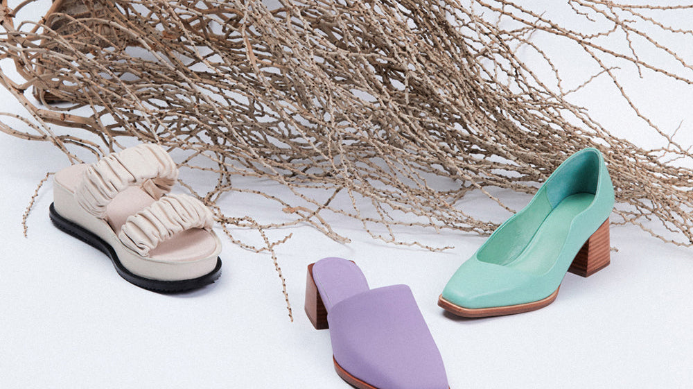 Three summer footwear shoes next to a dried flaxen plant