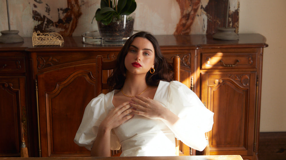 Person sitting at a table wearing a white dress