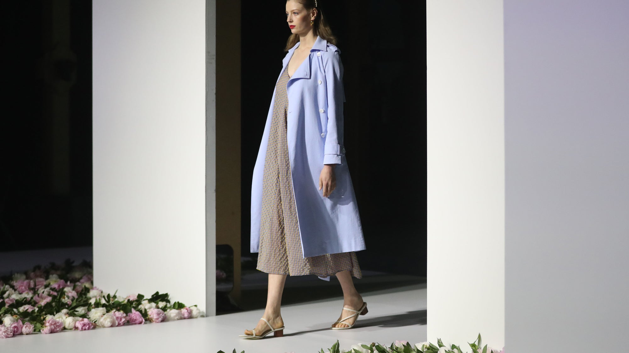 Person walking down a fashion runway wearing a dress