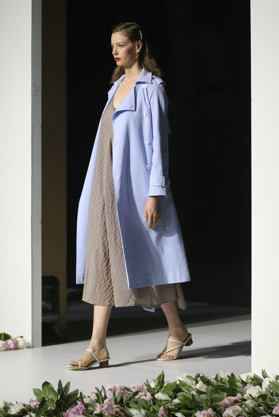 Person walking down a fashion runway wearing a dress
