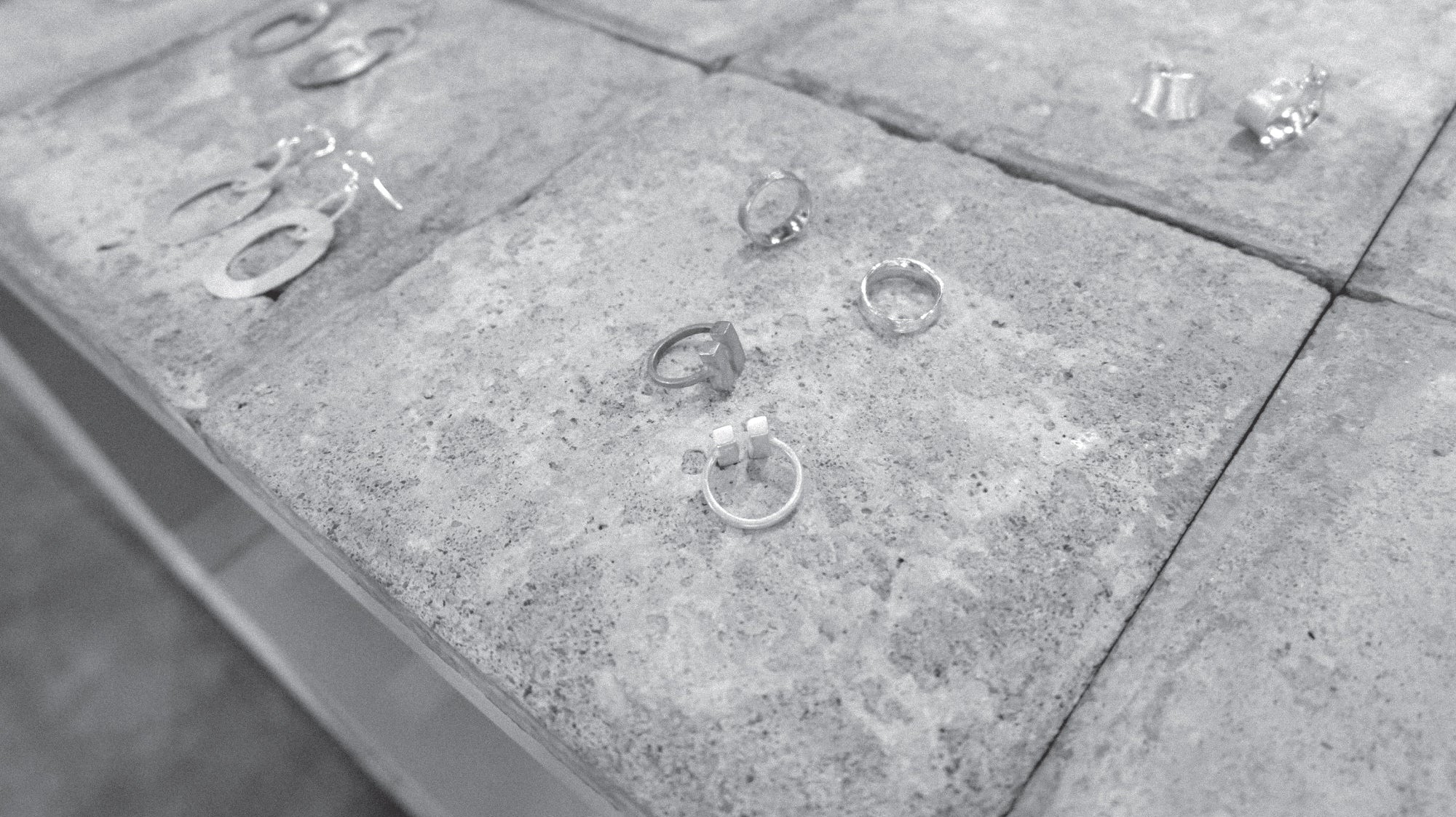 Jewellery pieces on a series of concrete tiles