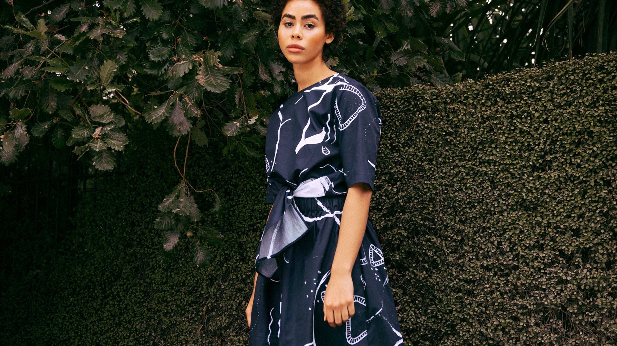 Person in a printed dark navy dress in a park