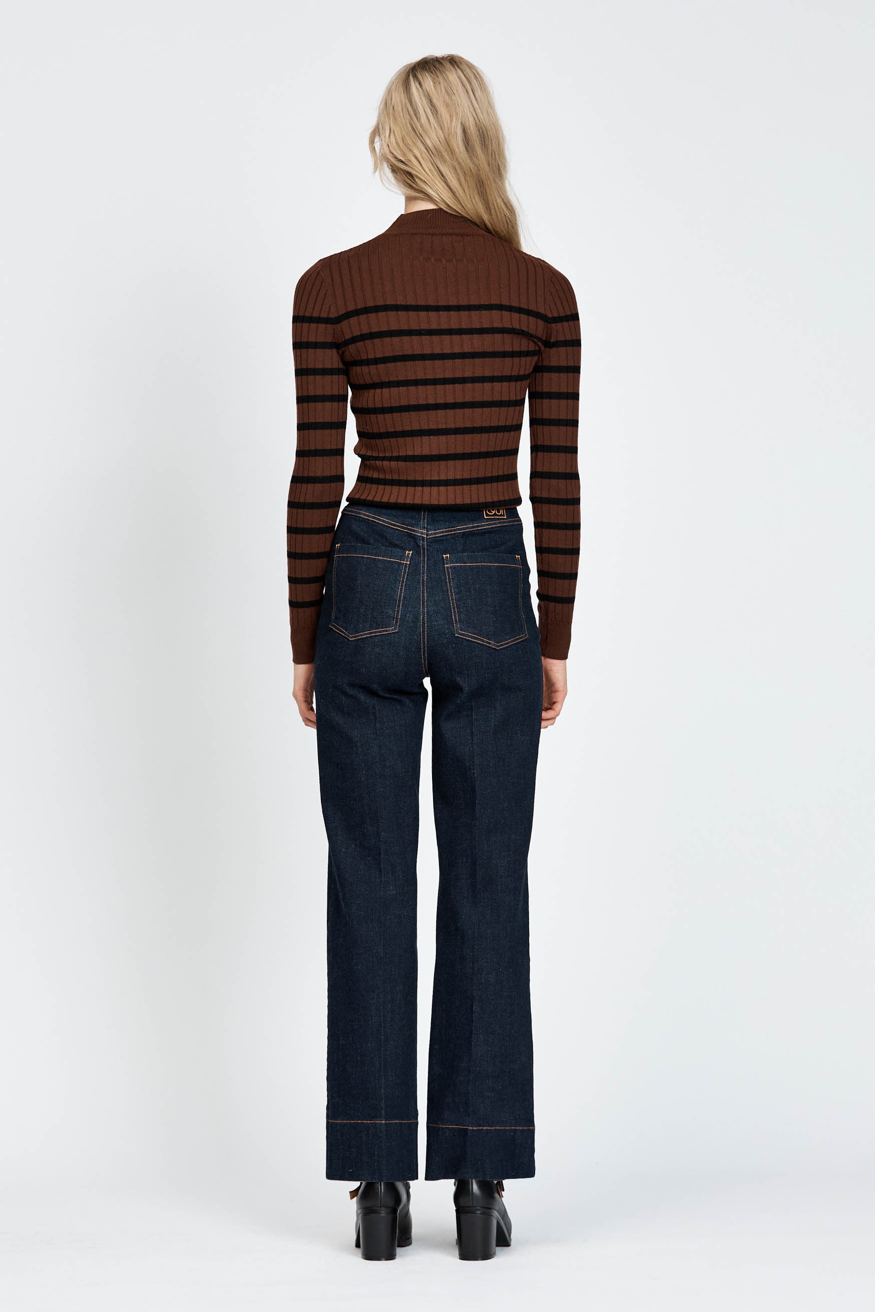 woman wearing dark denim jeans and brown black striped jumper