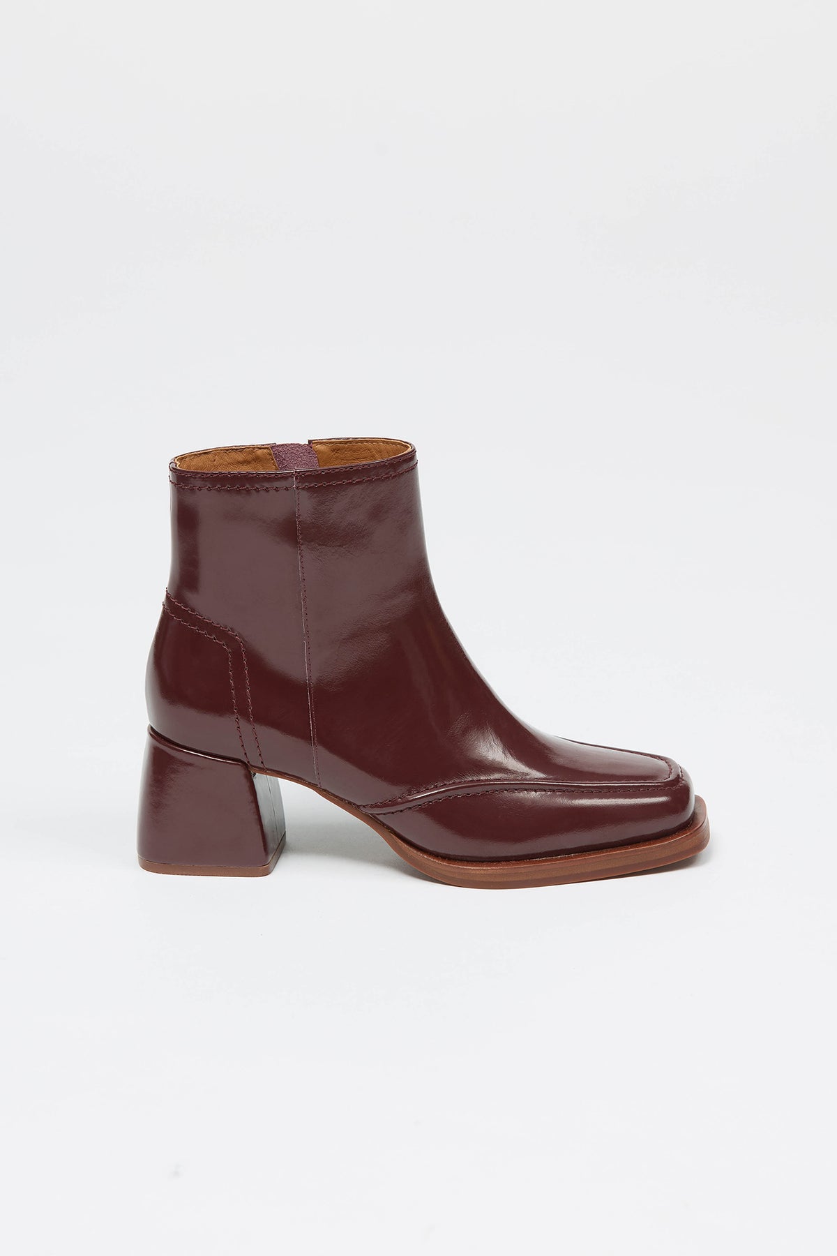 Woman wearing burgundy ankle boots with chunky heel