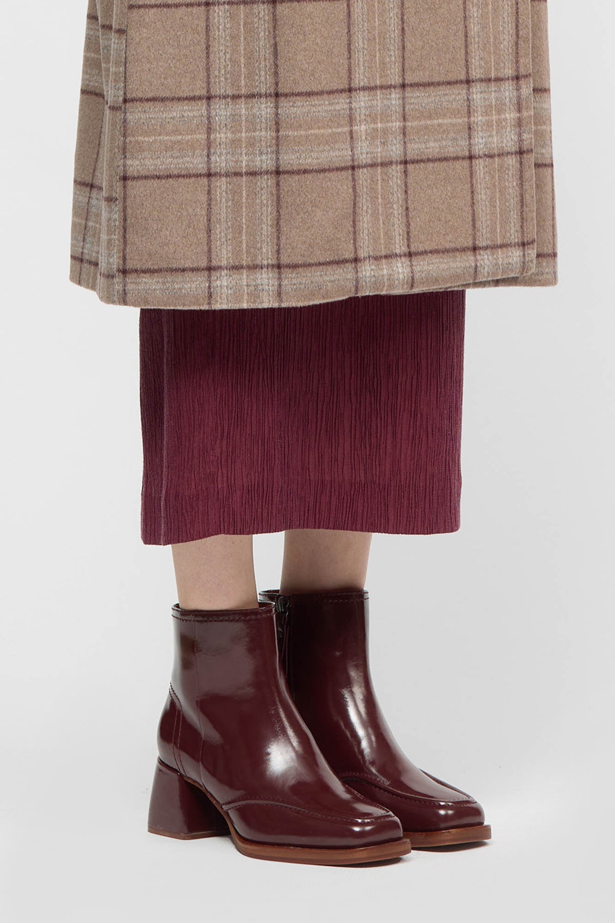 Woman wearing burgundy ankle boots with chunky heel
