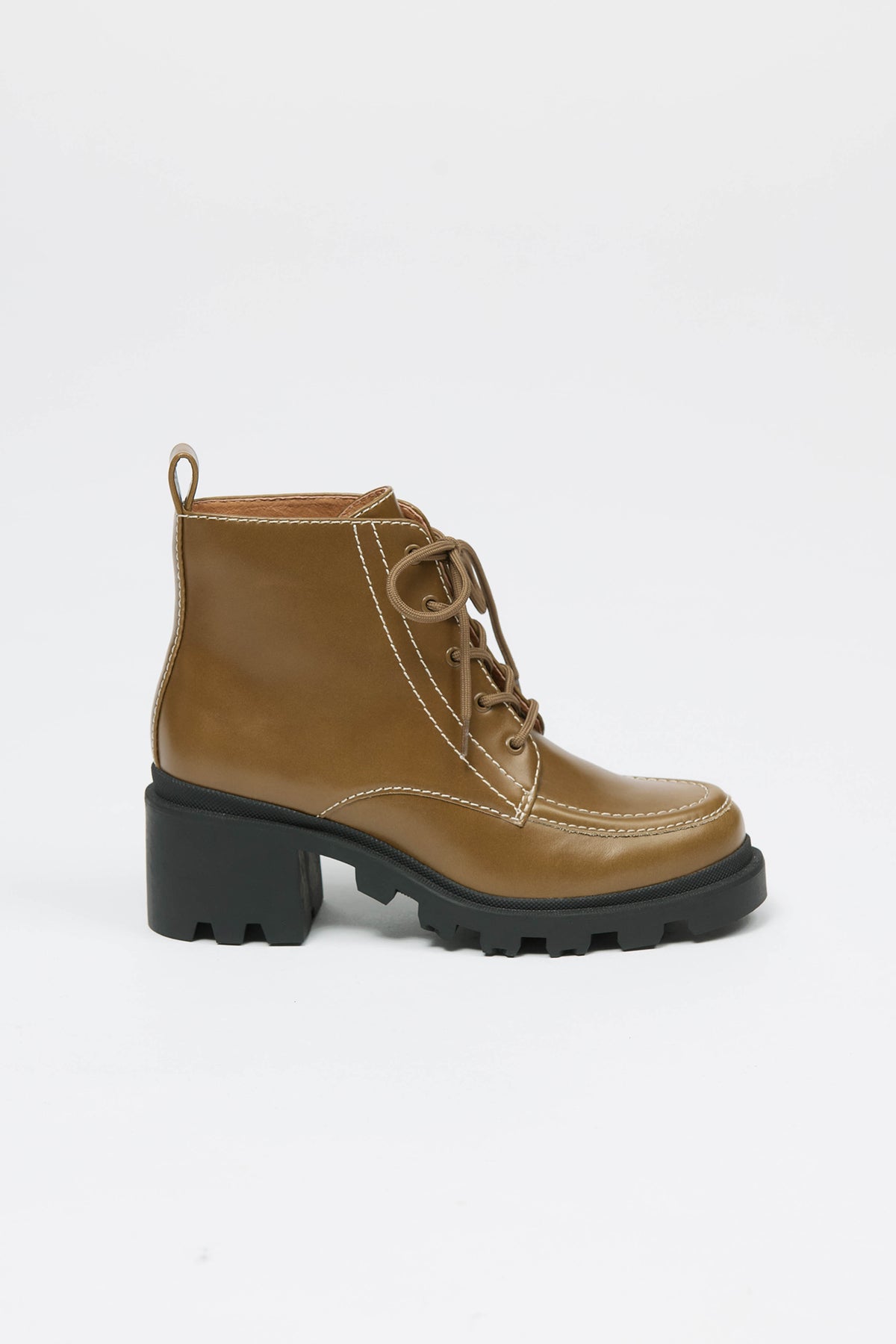 Woman wearing a lace up boot in olive with black sole
