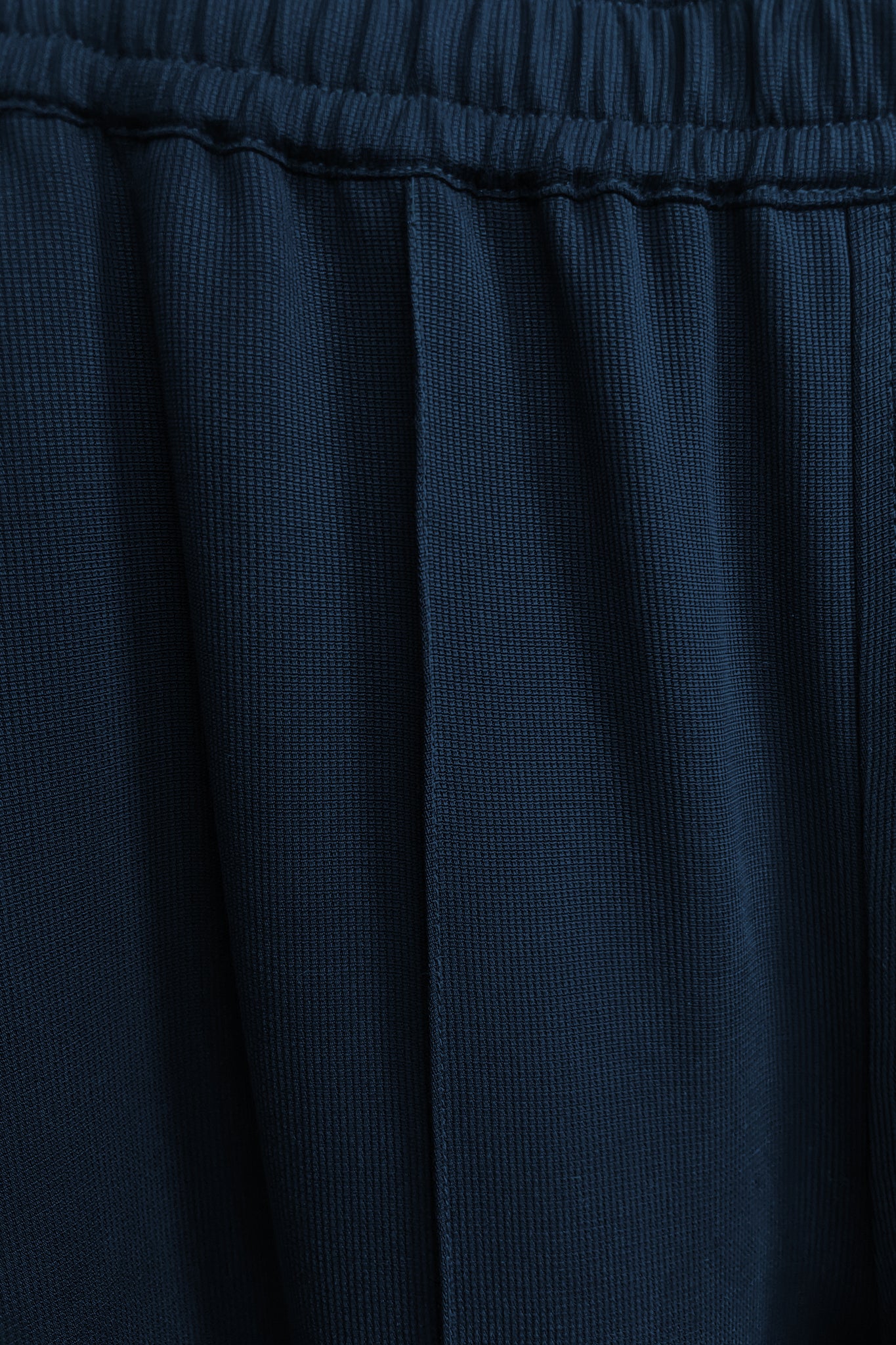 Model wearing a navy long pant in relaxed silhouette