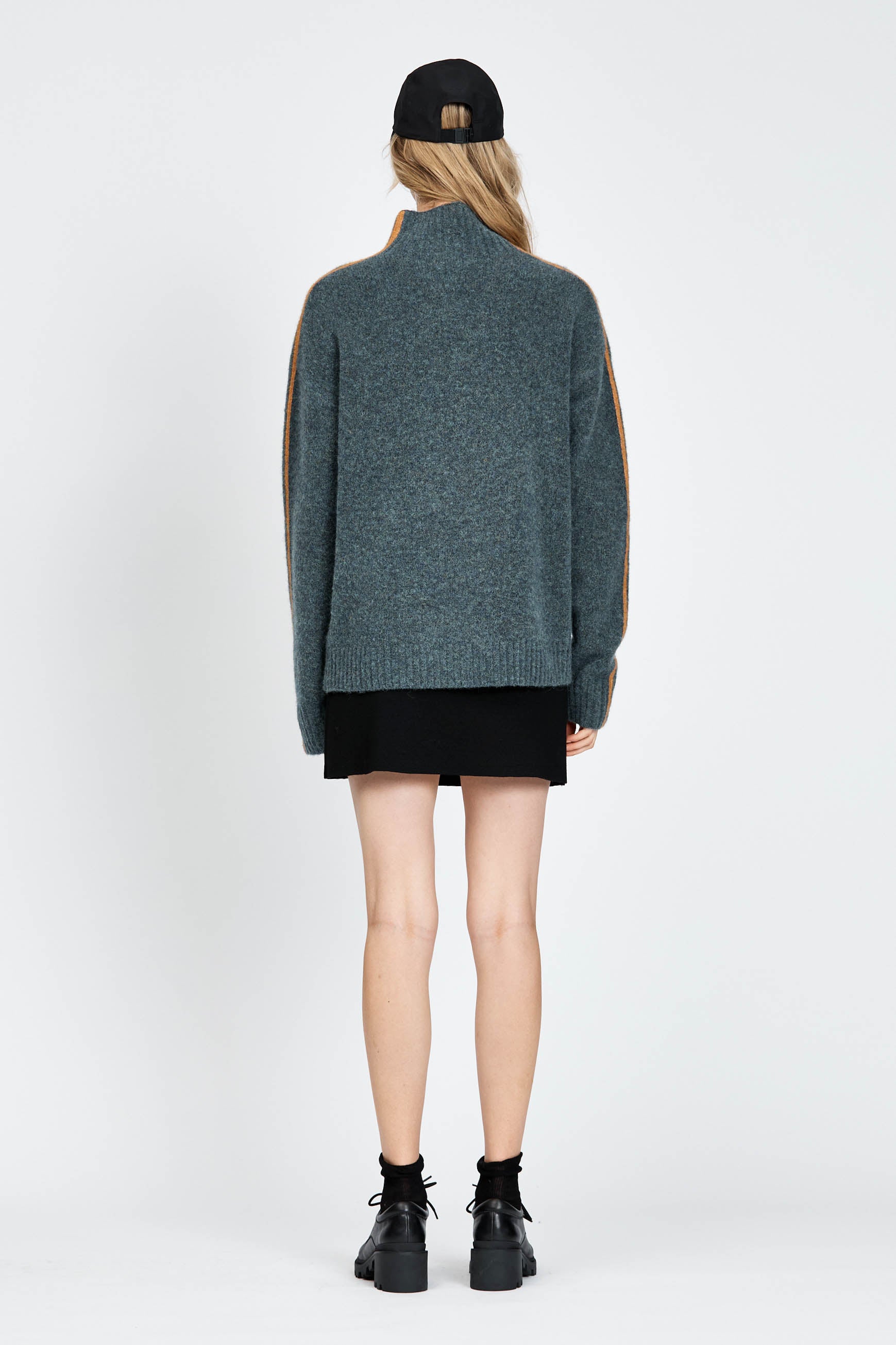 Woman wearing soft knitted jumper in blue with orange stripe