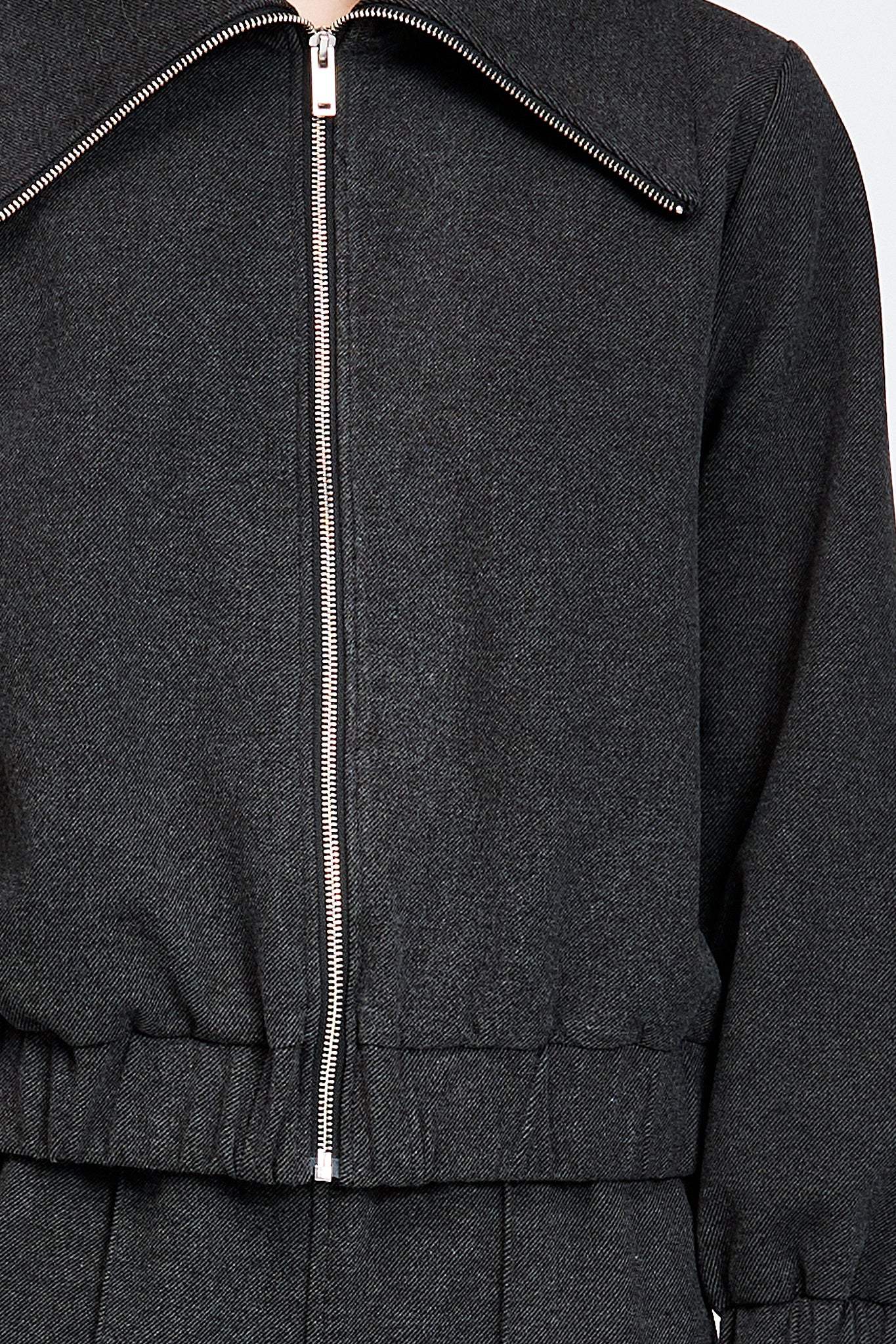 Model wearing a black jacket with zipper