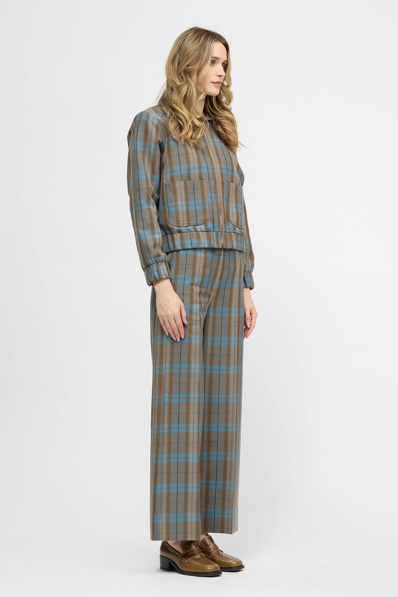 Woman wearing blue and brown check jacket with zipper closure