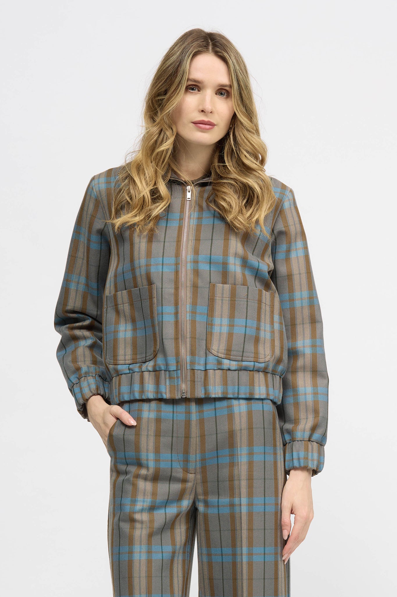 Woman wearing blue and brown check jacket with zipper closure