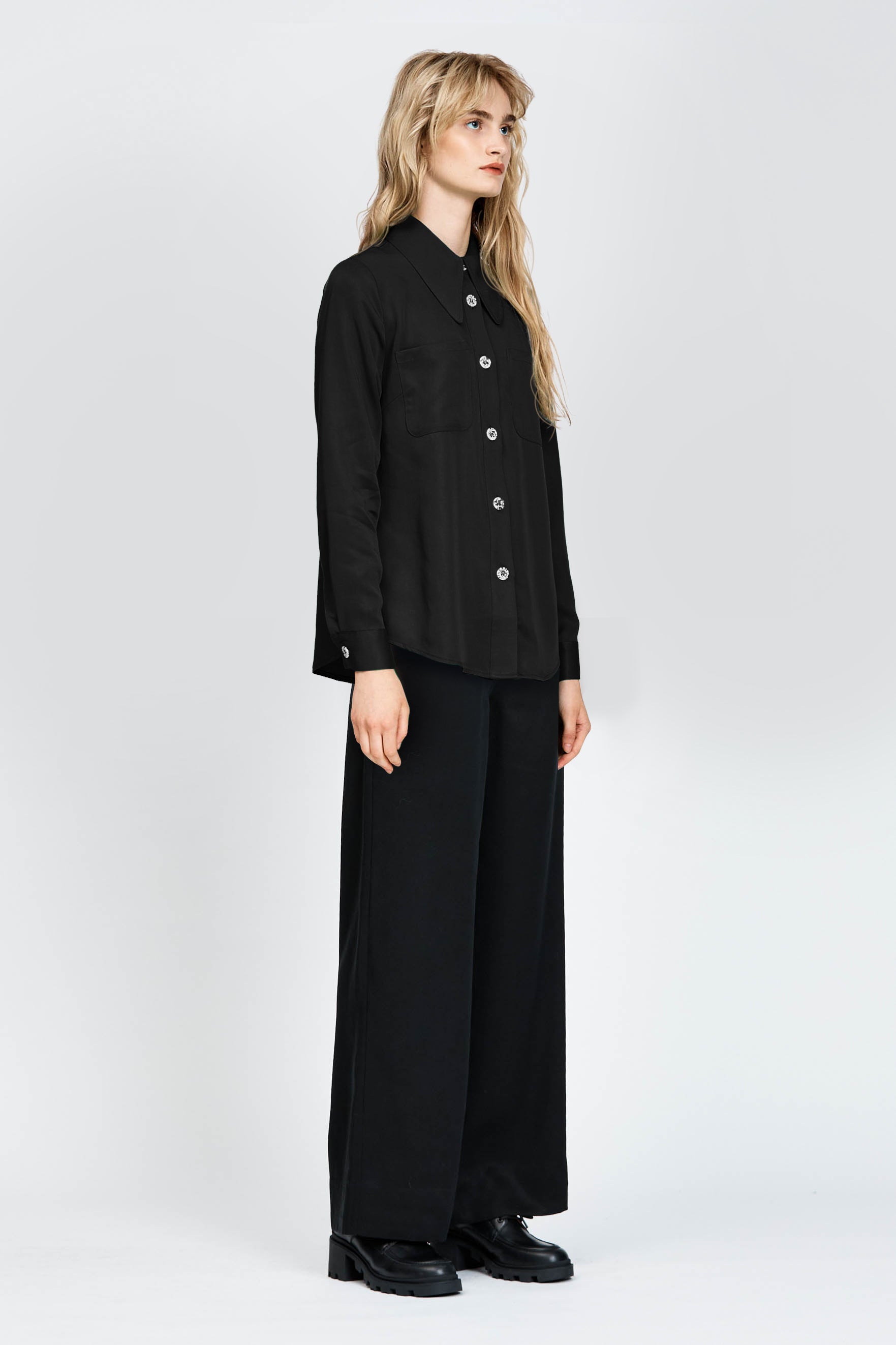 Woman wearing a long sleeve black shirt with white buttons