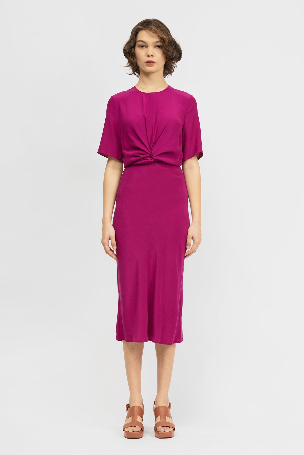 Woman wearing short sleeve midi length dress in magenta