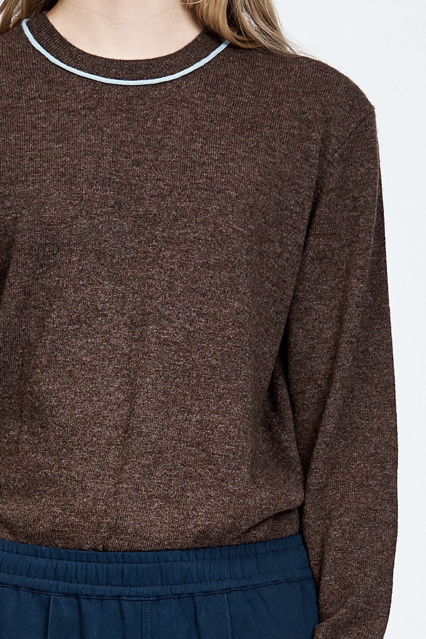 Woman wearing a brown long sleeve jumper