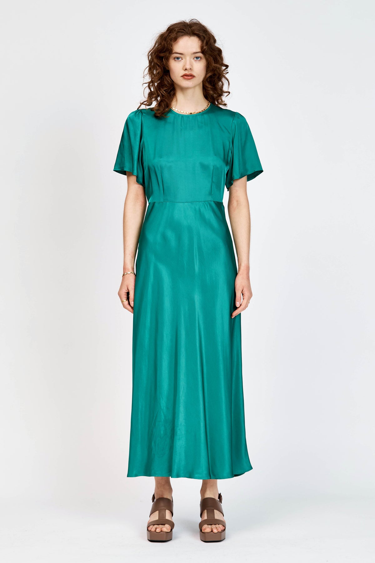 Model wearing green short sleeve, mid-length dress in viscose fabric