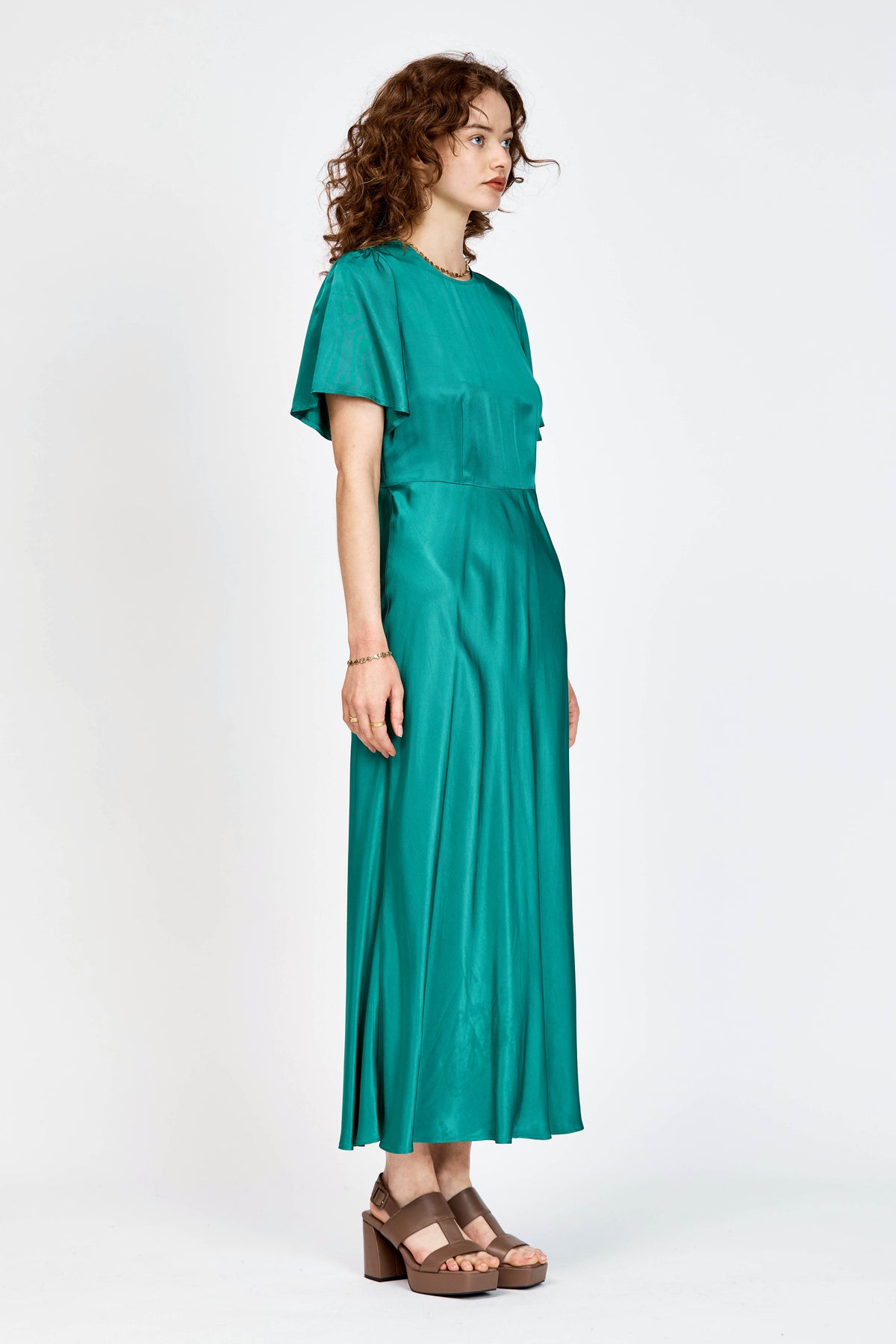 Model wearing green short sleeve, mid-length dress in viscose fabric