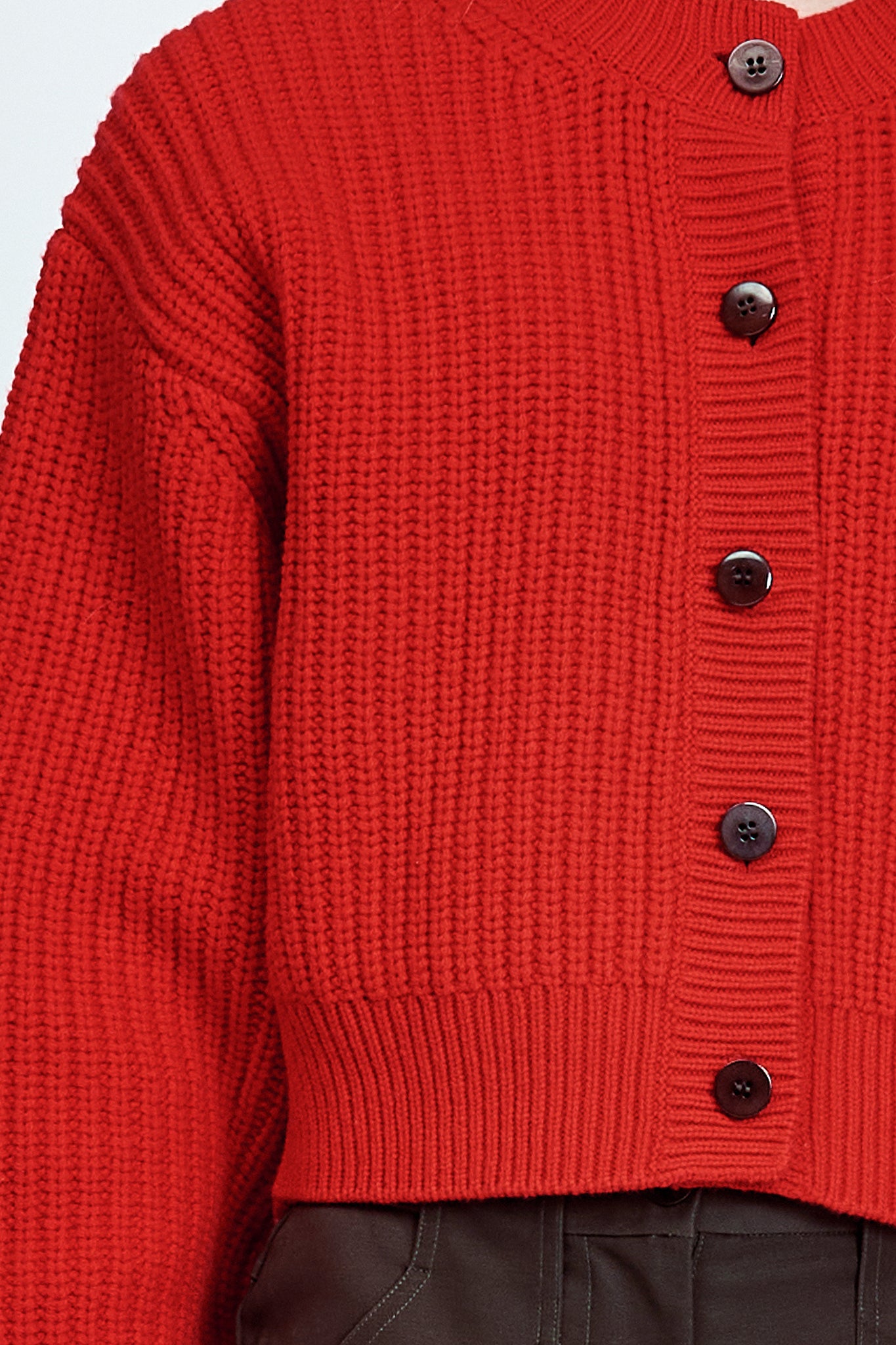 Woman wearing cable knit cardigan in red