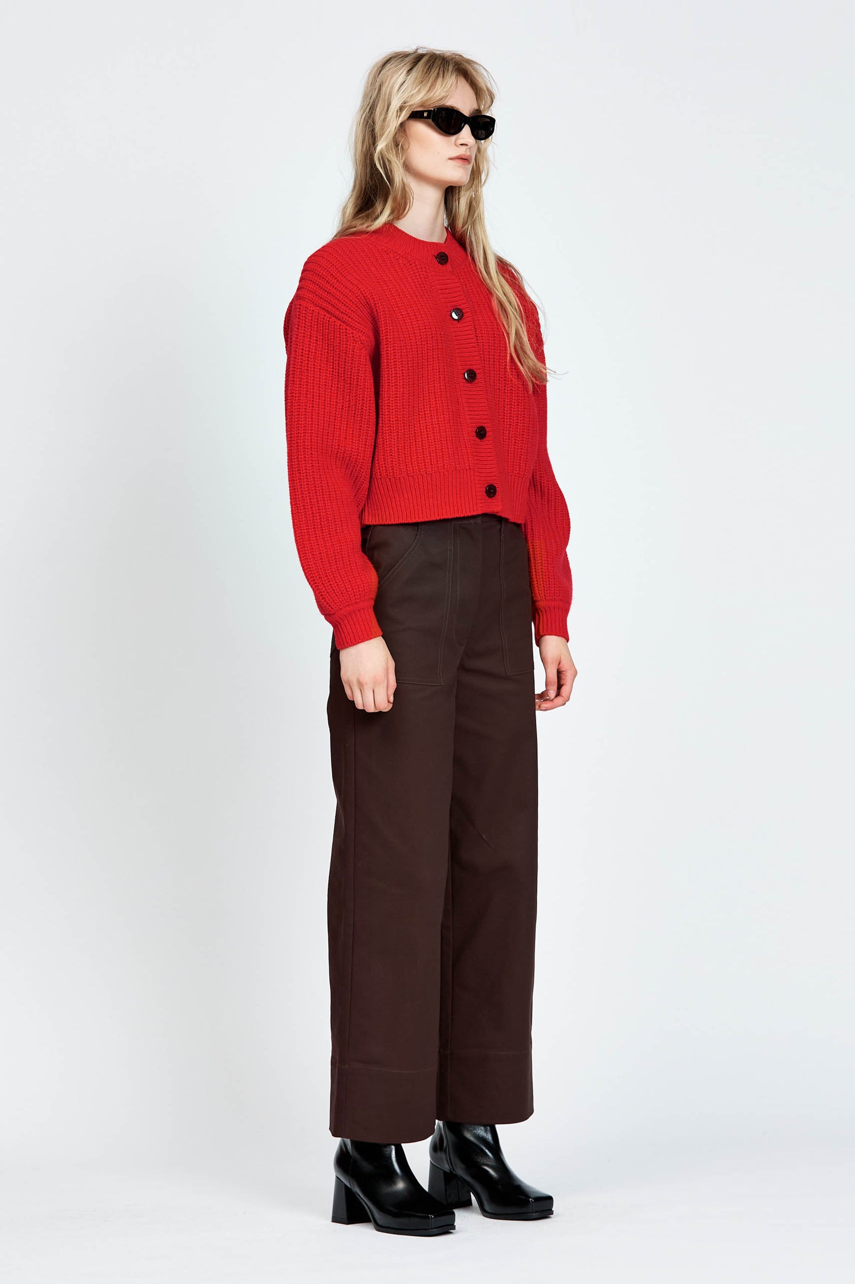 Woman wearing cable knit cardigan in red