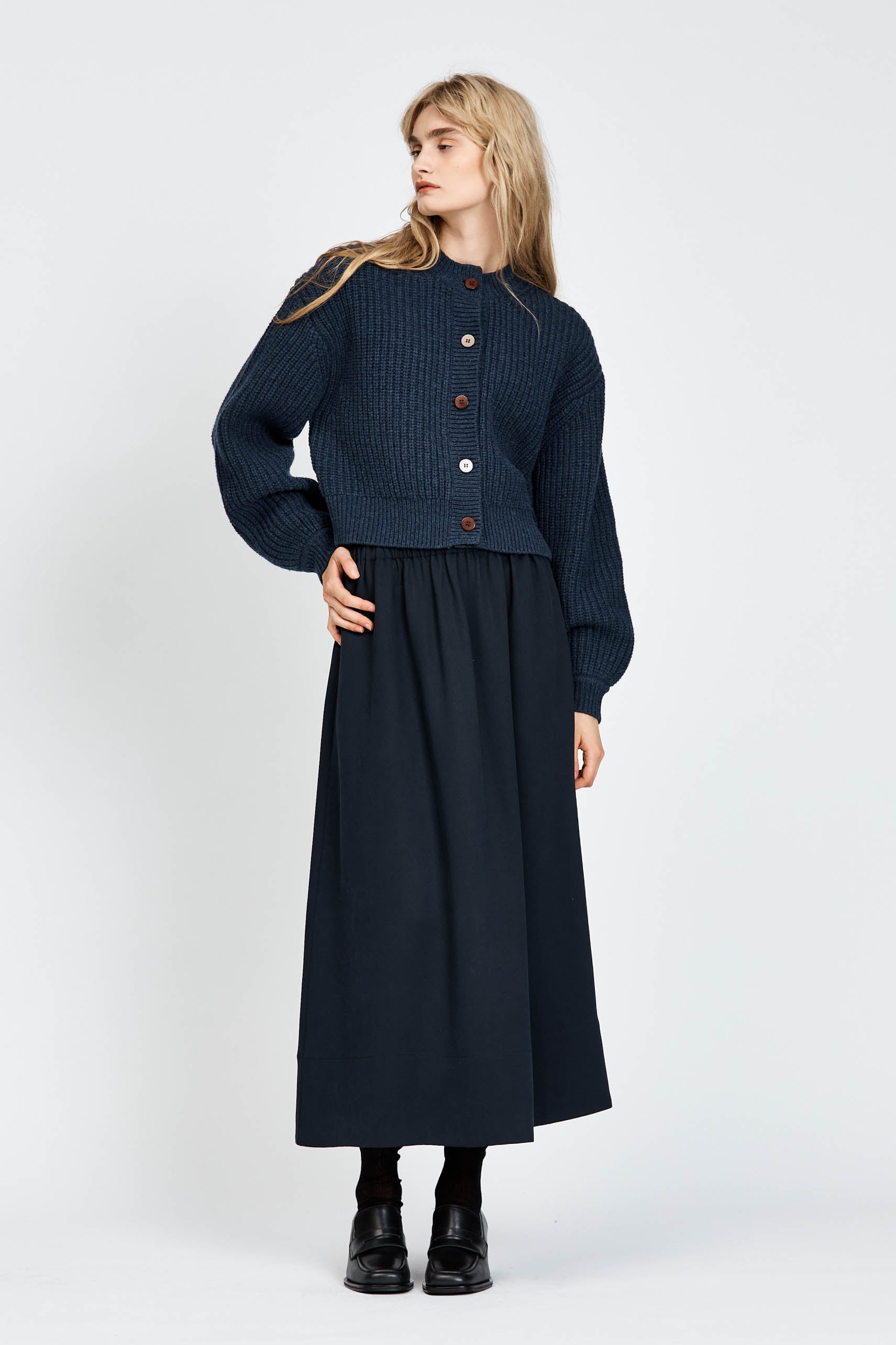 Woman wearing cable knit cardigan in navy