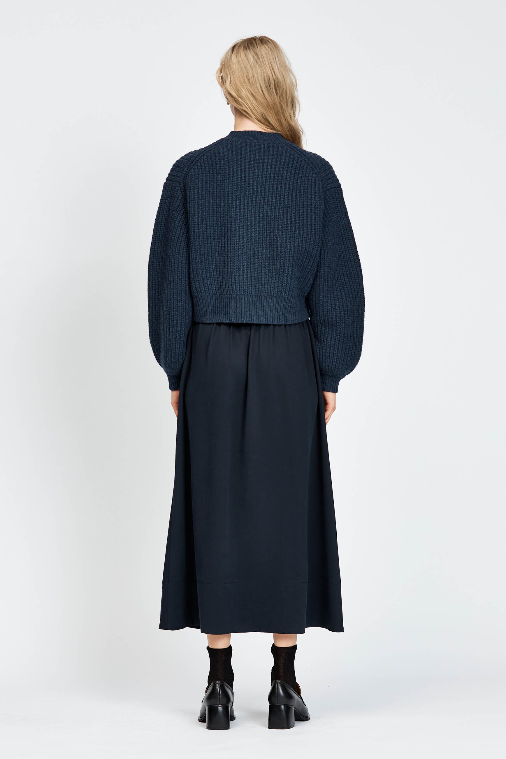 Woman wearing cable knit cardigan in navy