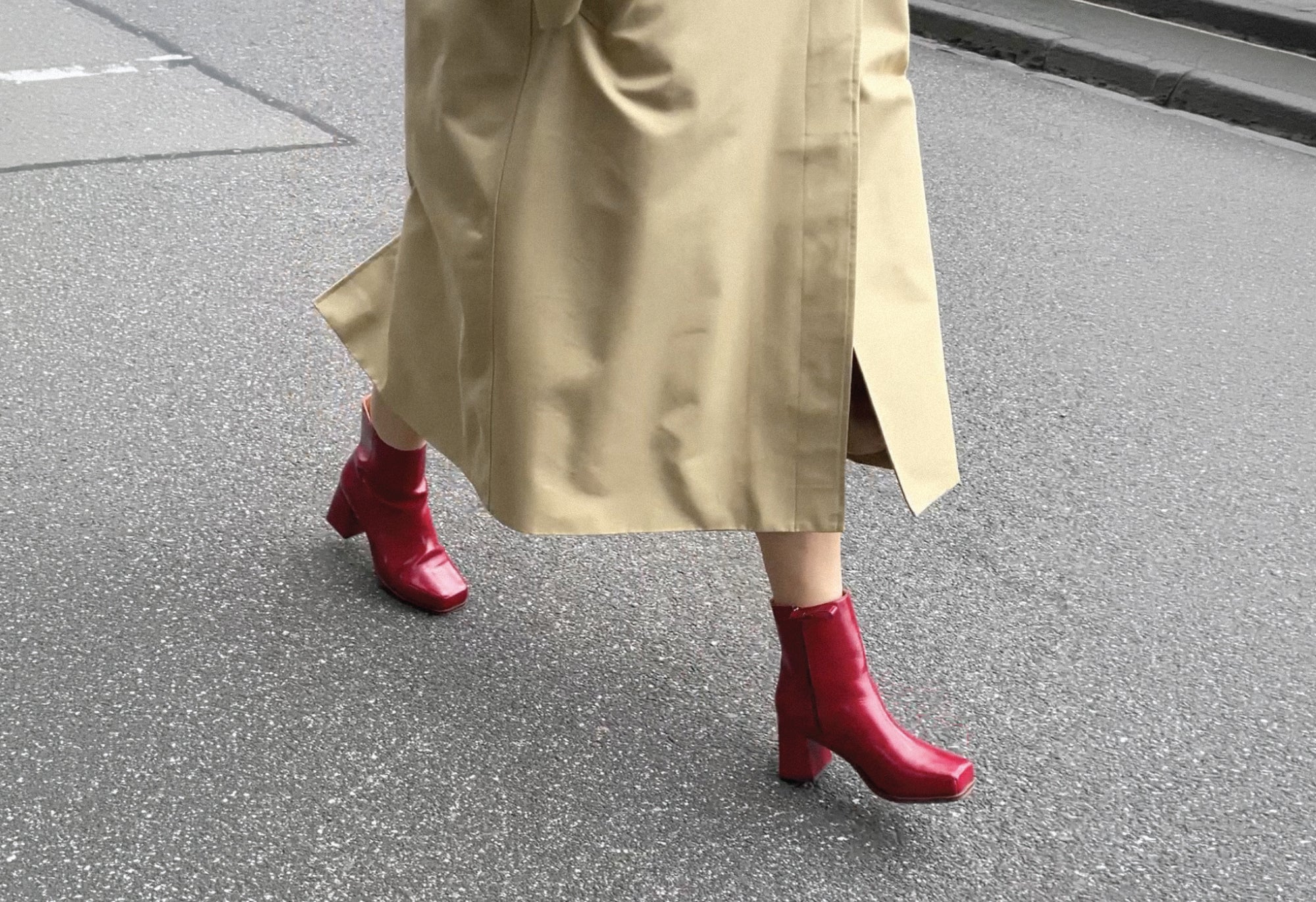 Women walking in red boots with beige trench coat