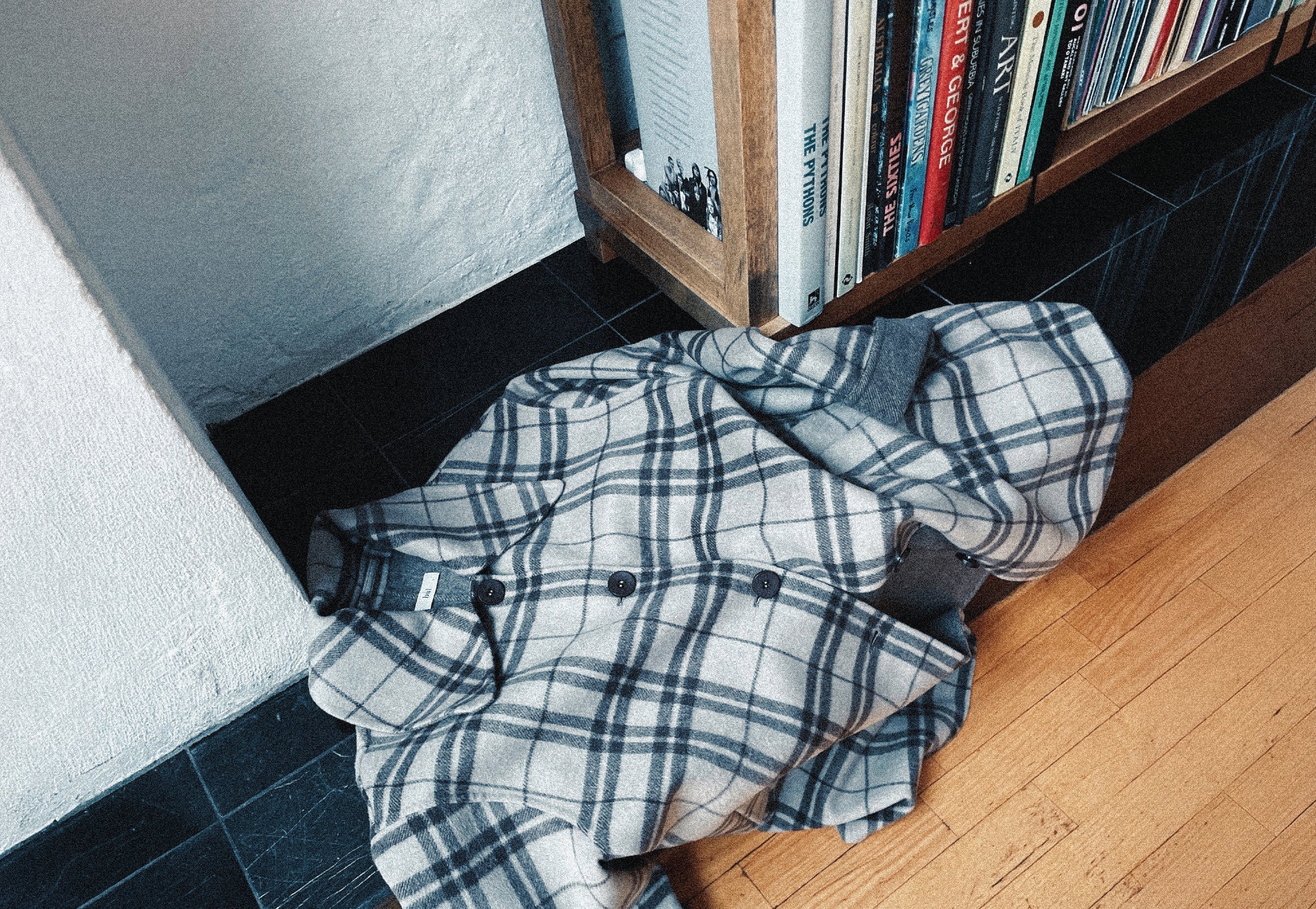 Checked coat next to bookcase