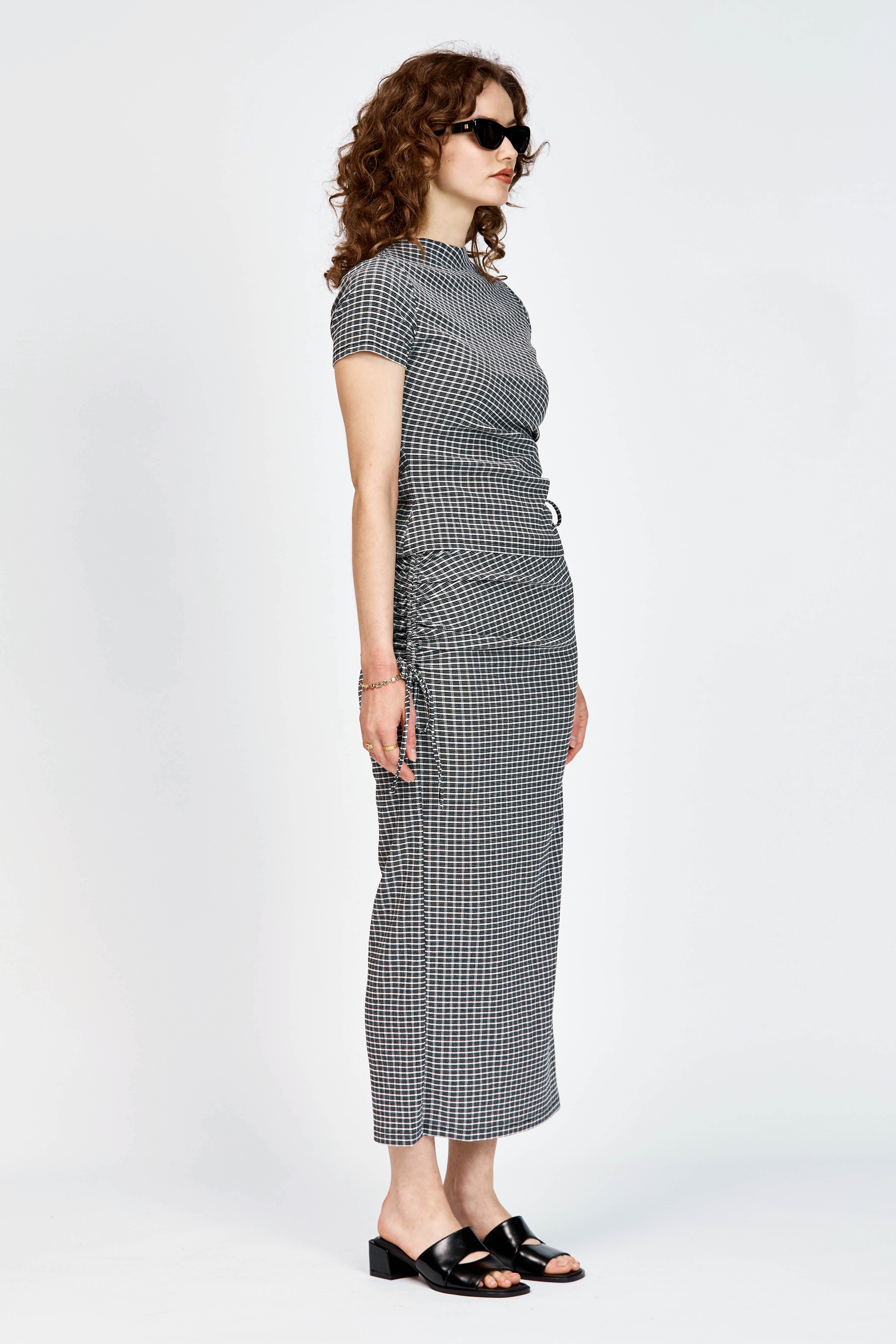 Model wearing a matching top and skirt in black and white check fabric