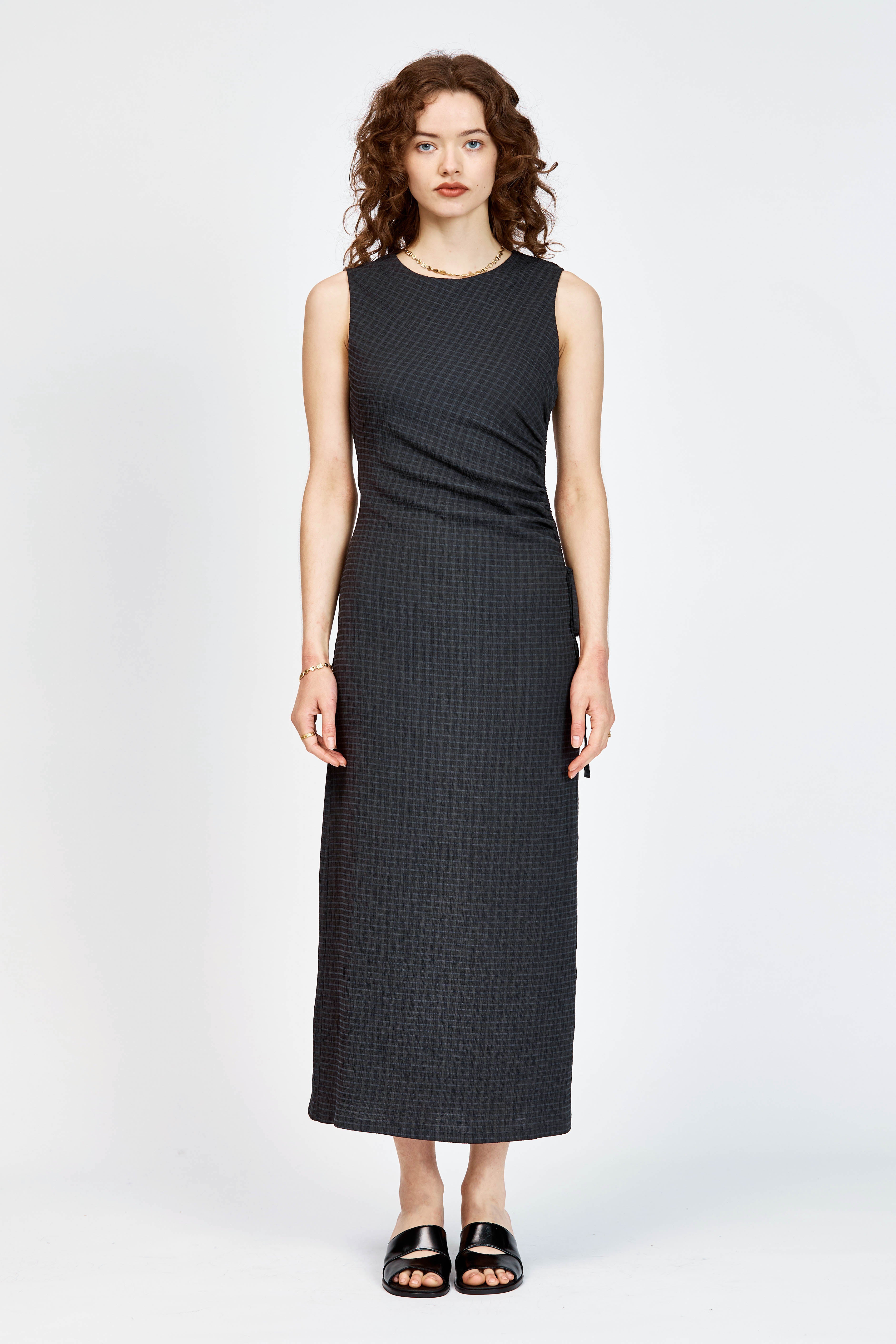 Model wearing black and navy check long dress with waist tie detailing