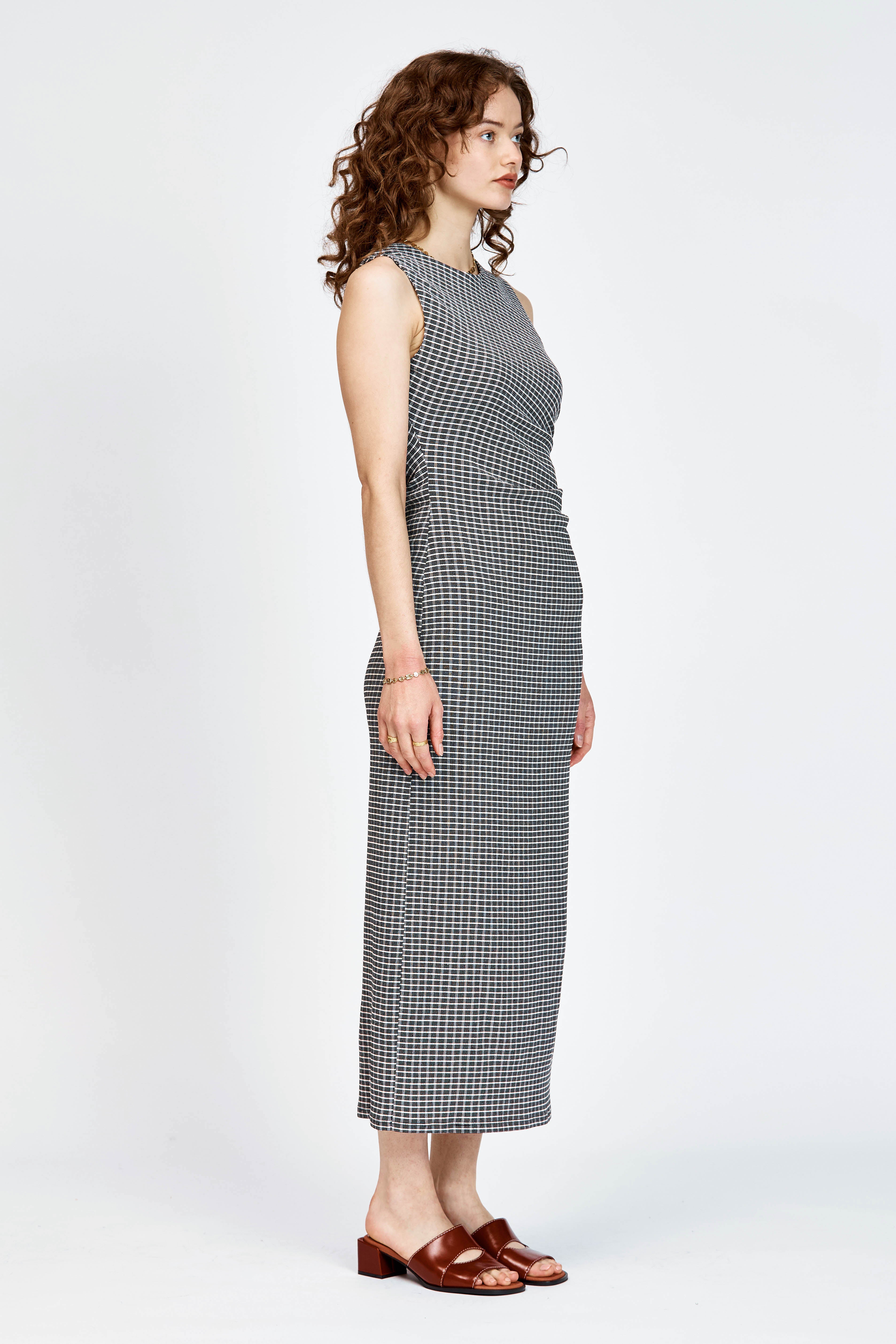 Model wearing fitted black and white check dress with waist tie detailing