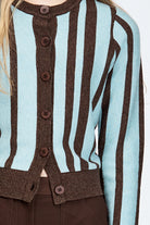 Woman wearing a woollen cardigan with brown and blue stripes