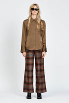 Model wearing a pair of brown check pants