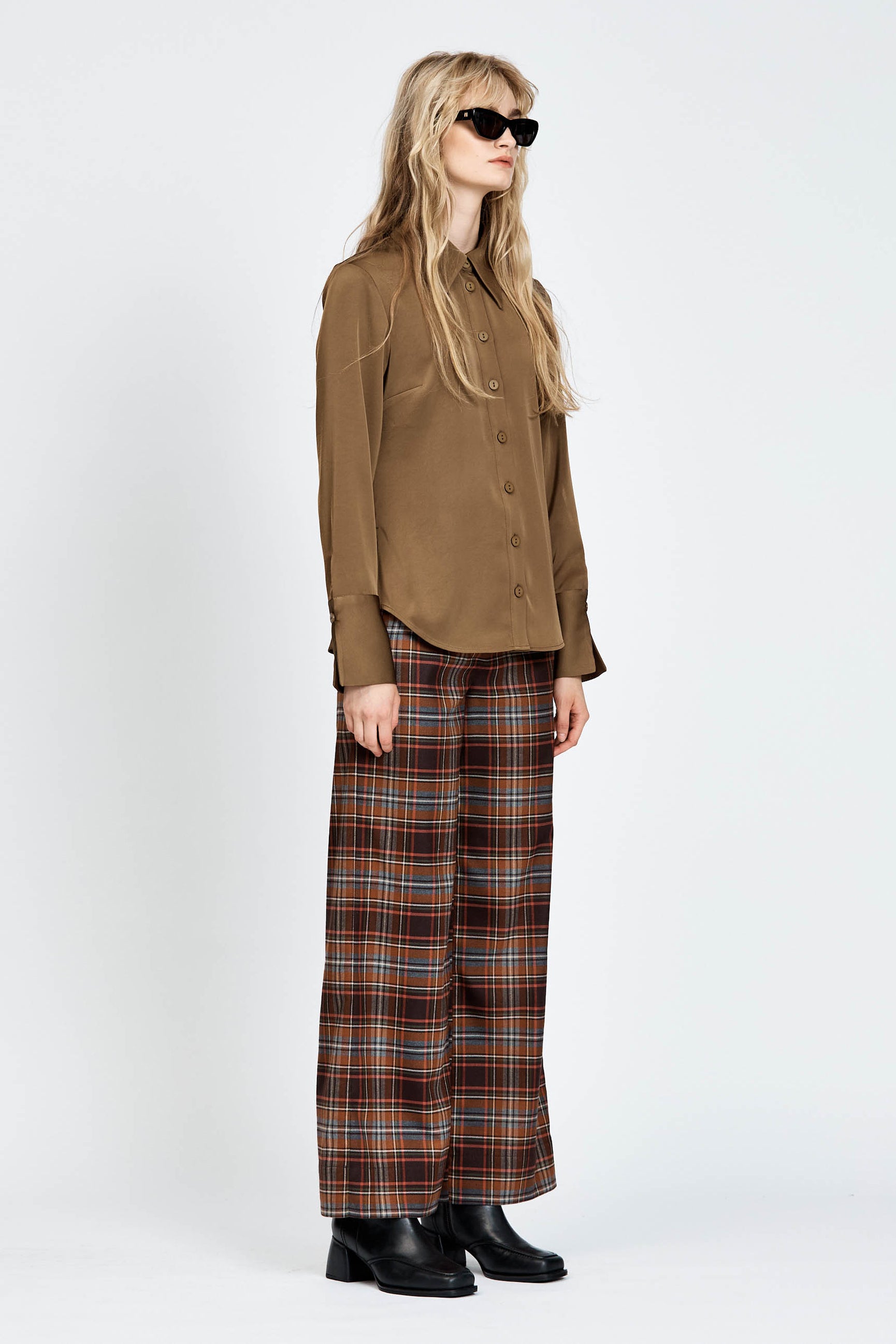 Model wearing a pair of brown check pants