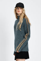 Woman wearing soft knitted jumper in blue with orange stripe