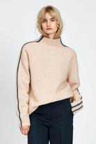 Woman wearing a soft knitted jumper in sand with blue stripe