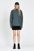 Woman wearing soft knitted jumper in blue with orange stripe
