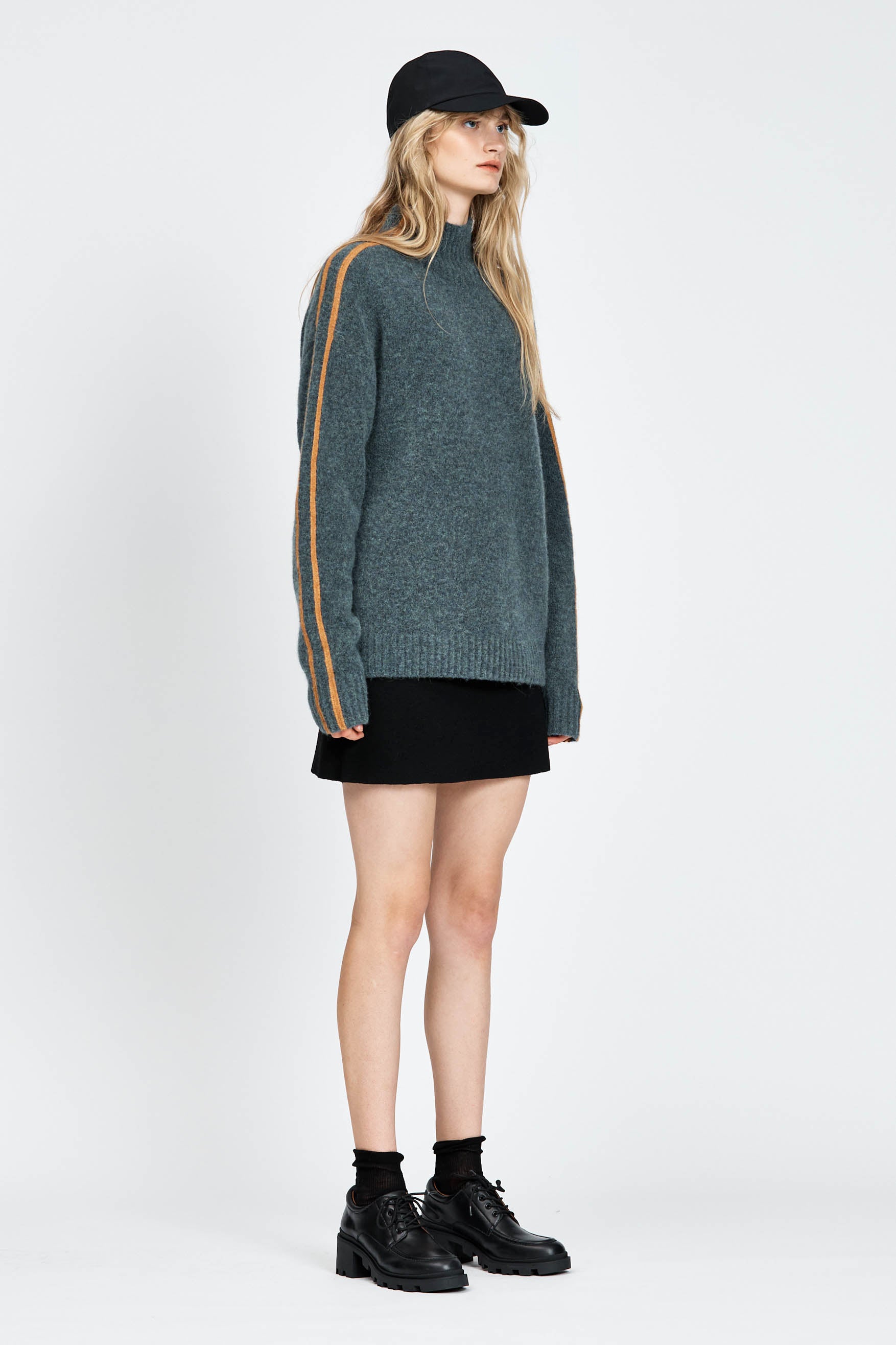 Woman wearing soft knitted jumper in blue with orange stripe