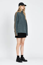 Woman wearing soft knitted jumper in blue with orange stripe