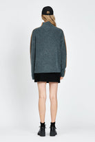 Woman wearing soft knitted jumper in blue with orange stripe