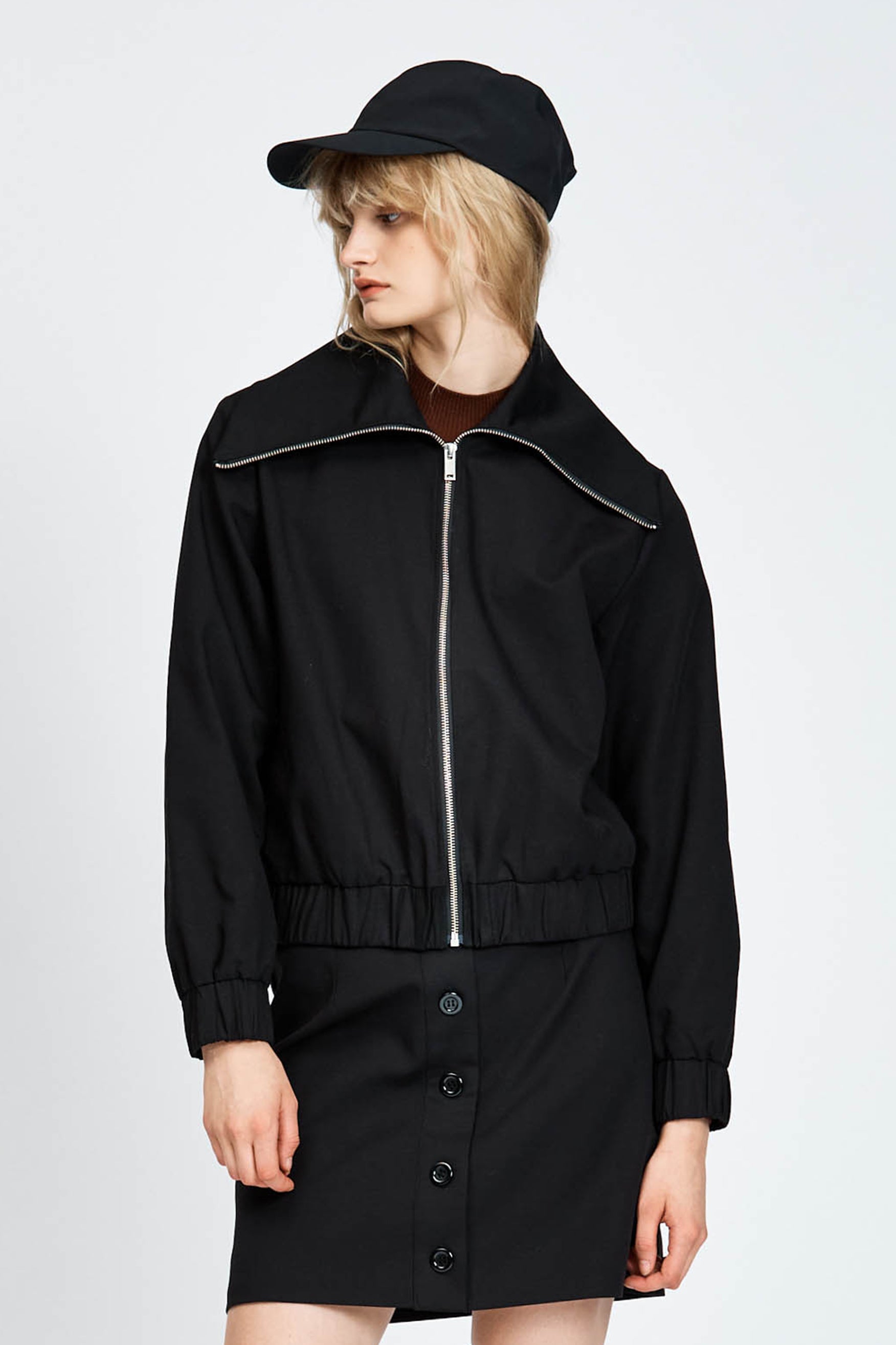 Model wearing a black jacket with zipper