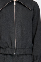 Model wearing a black jacket with zipper