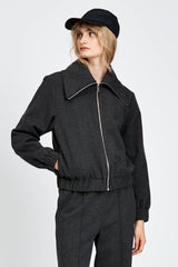 Model wearing a black jacket with zipper