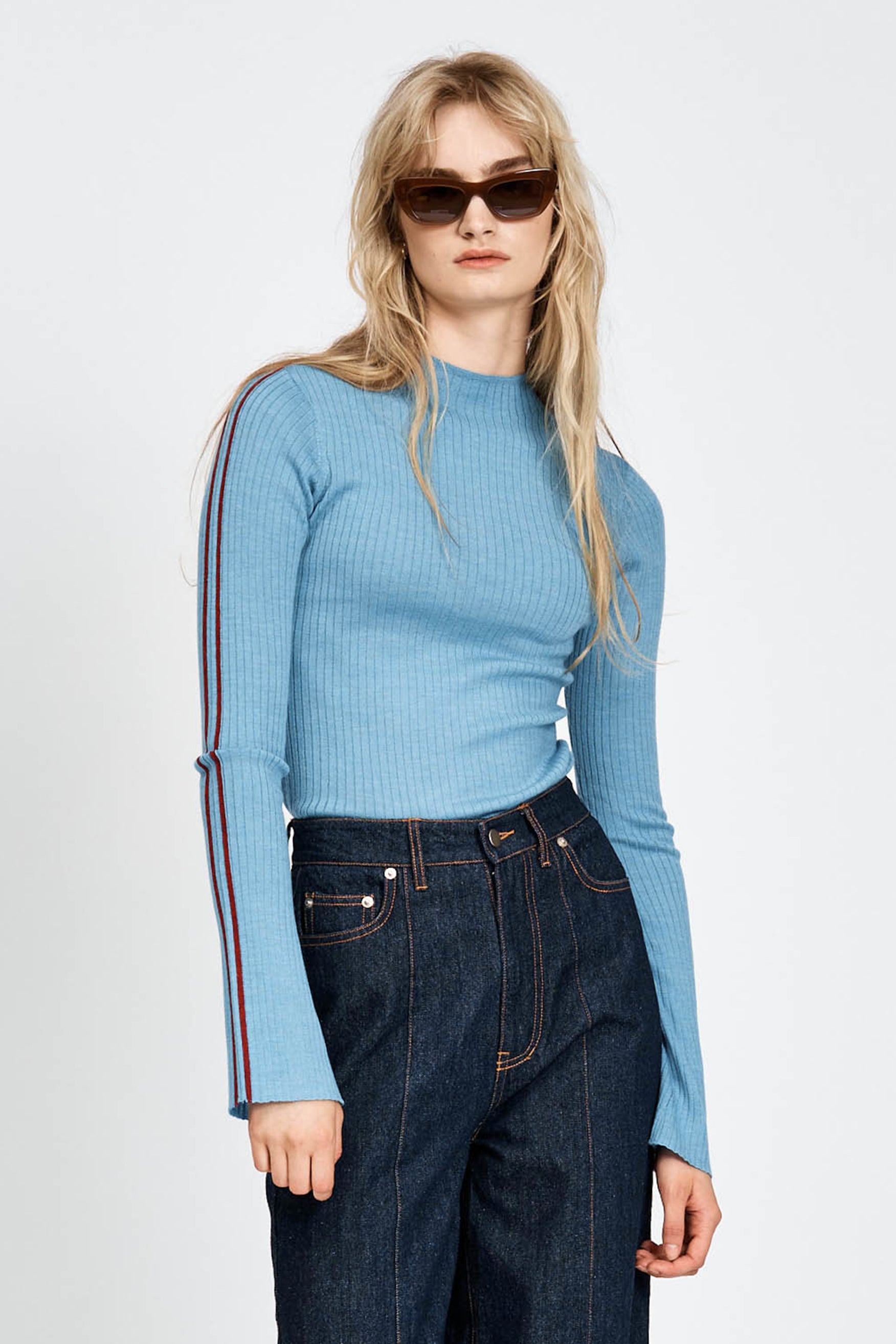 Woman wearing blue knitted top with red stripe