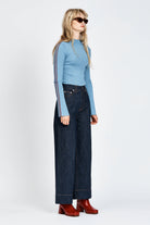 Woman wearing blue knitted top with red stripe