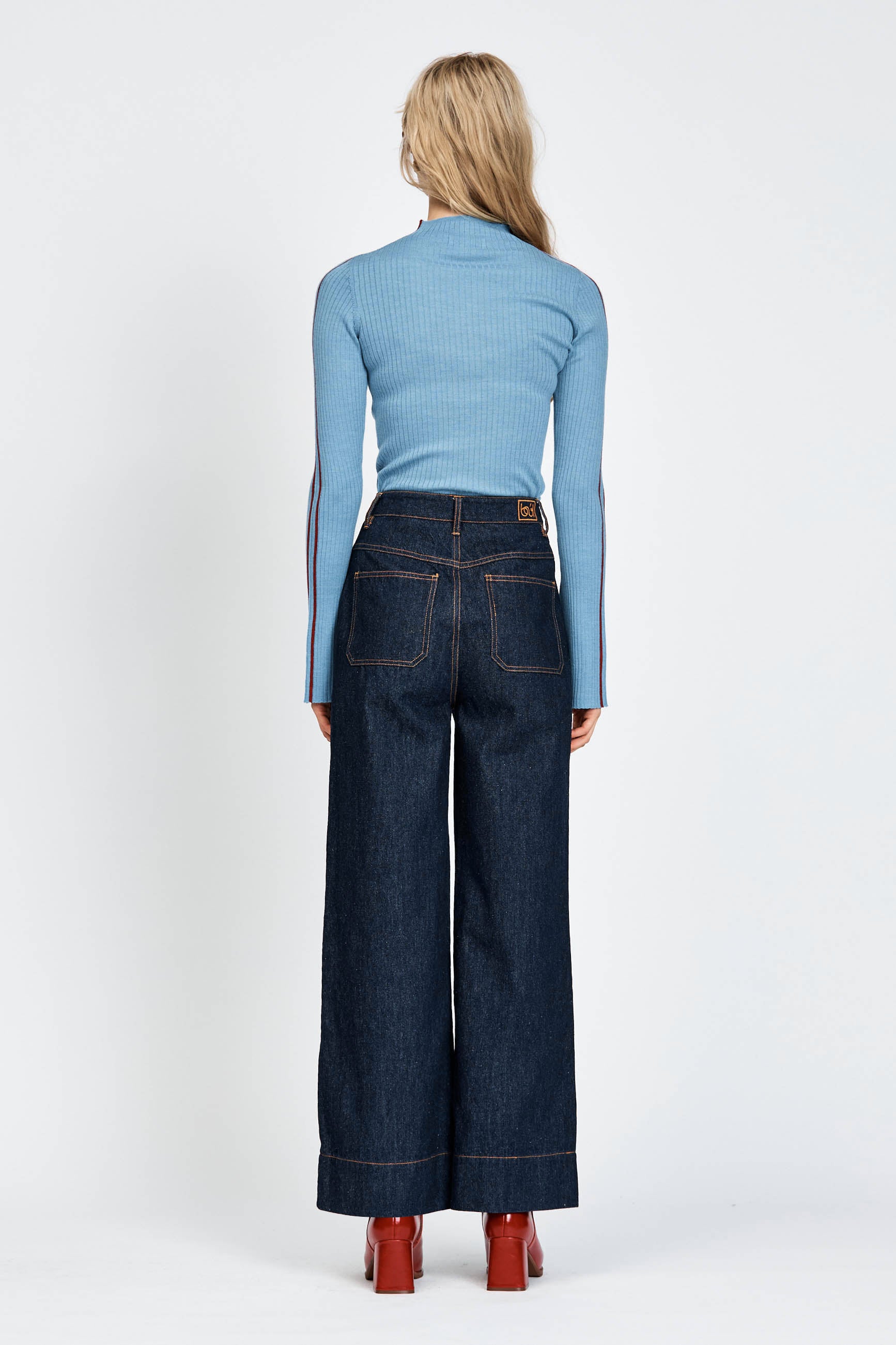 Woman wearing blue knitted top with red stripe