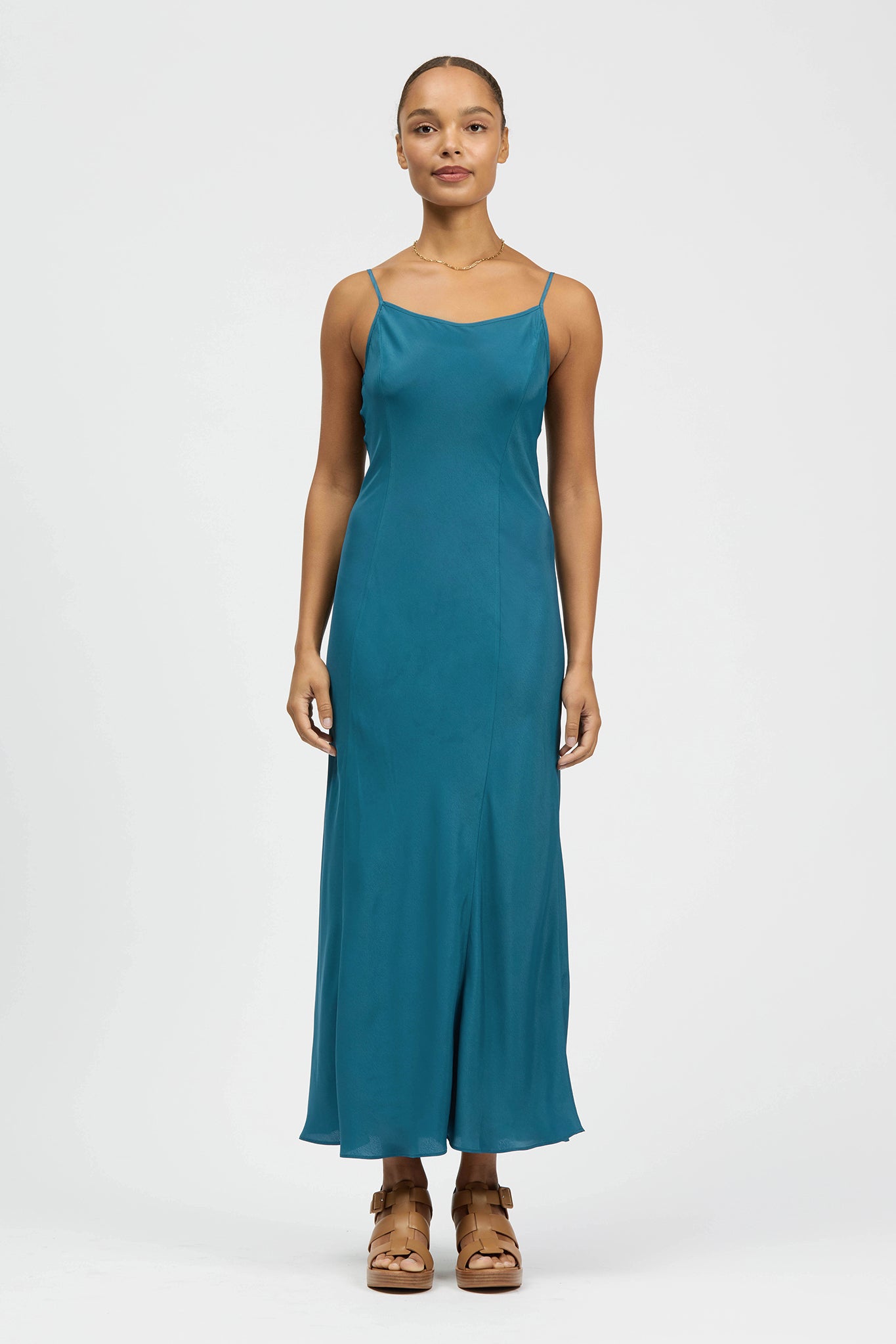Woman wearing strappy slip dress in petrol colour
