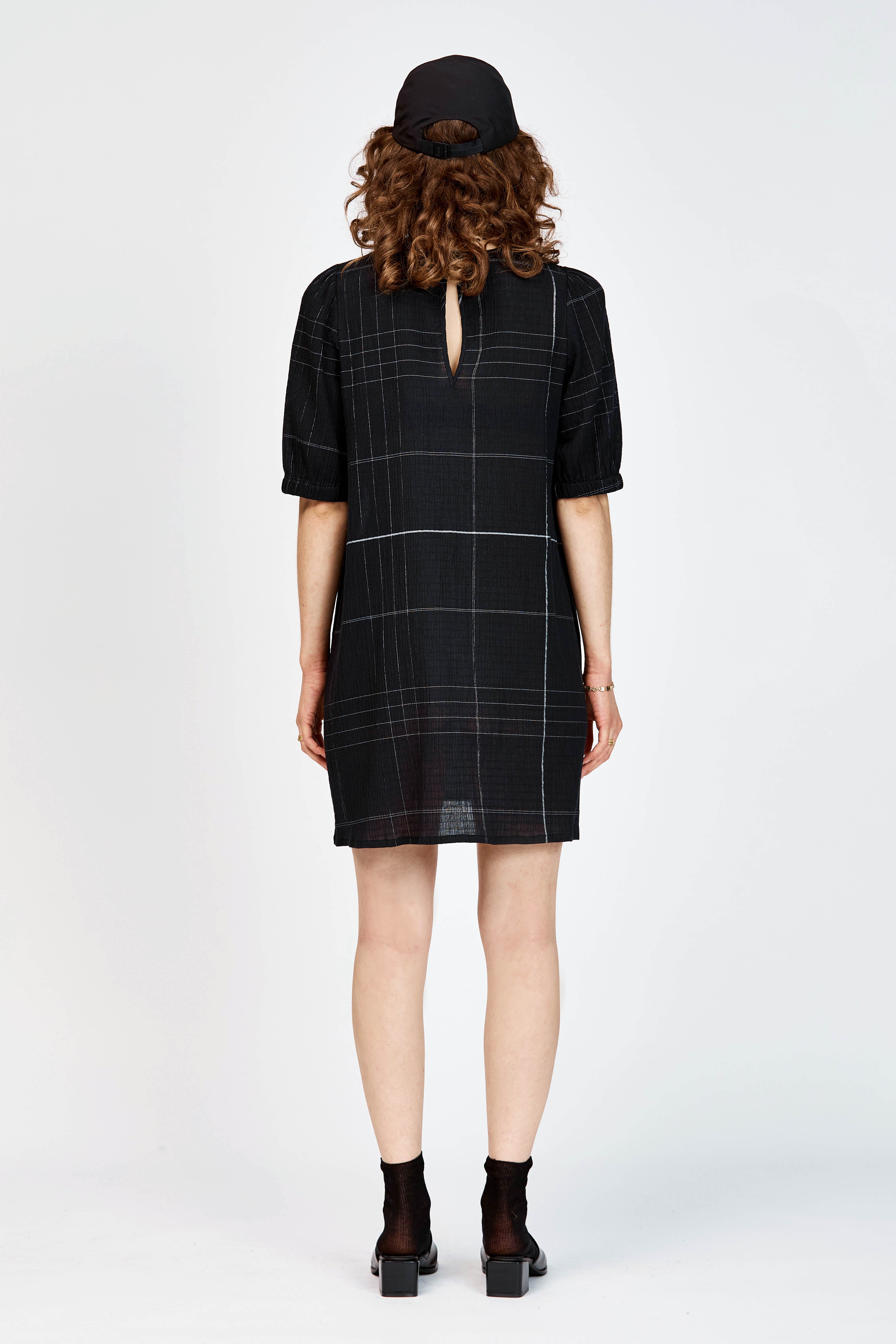 Model wearing a black and white check mini dress