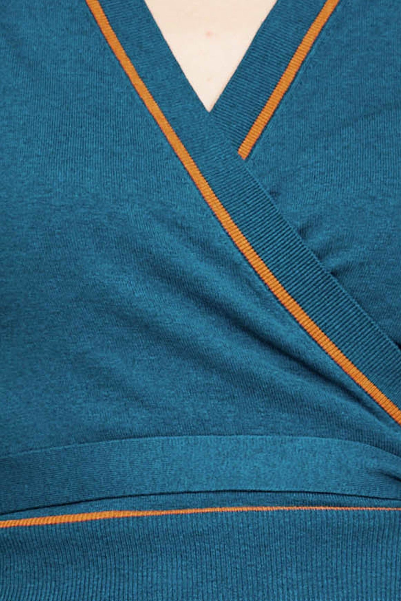 Fabric swatch of teal wrap-style short-sleeve top with thin orange trim along neckline and arms
