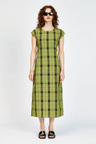 Model wearing an olive and black check midi length dress with a tie waist detail